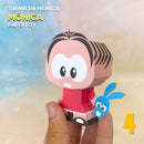 Vista lateral do Papertoy Mônica mostrando os detalhes do cabelo, sandálias e acabamento artesanal