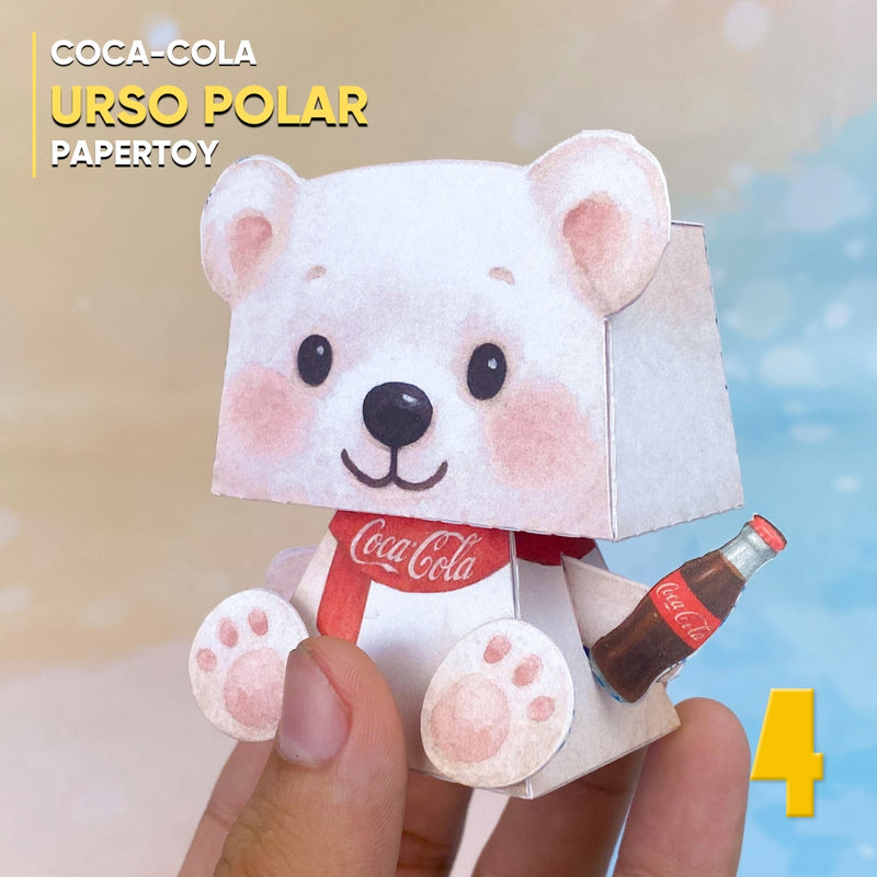 Detalhe frontal do Papertoy Urso da Coca-Cola mostrando traços delicados e acabamento artesanal